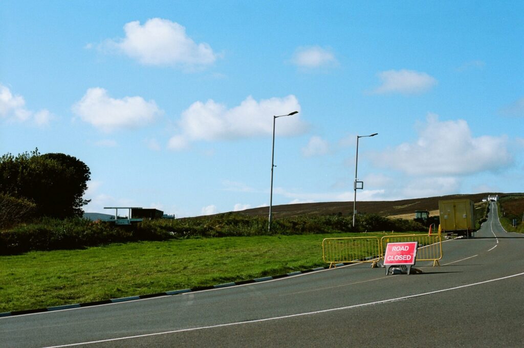 Stock photograph of a roadside caution sign next to yellow barriers, used to illustrate an article about soft 404 errors. It is not a photograph of a client site or of any real incident.