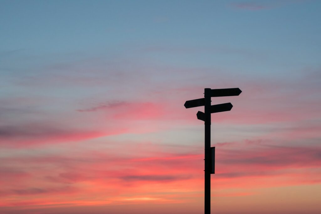 Stock photograph of a signpost with arrows pointing in opposite directions, used as an illustration of conflicting signals.