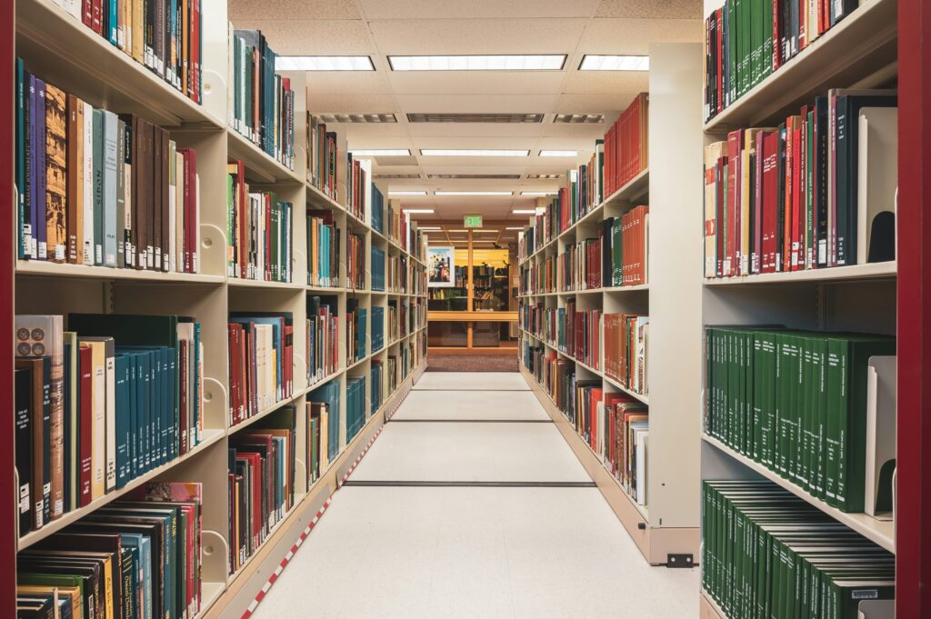 Stock photo of a long row of books along library shelves, used here to illustrate a paginated listing. It is not a screenshot of a website.