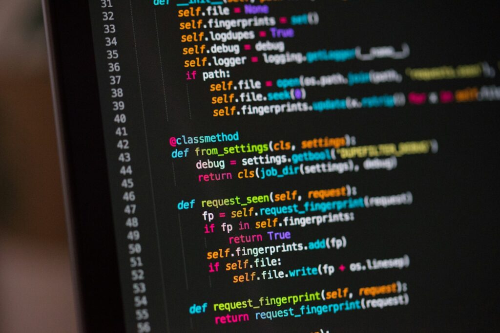 Stock photograph of coloured lines of code displayed on a computer monitor. A generic illustration, not a screenshot of any specific site's markup.