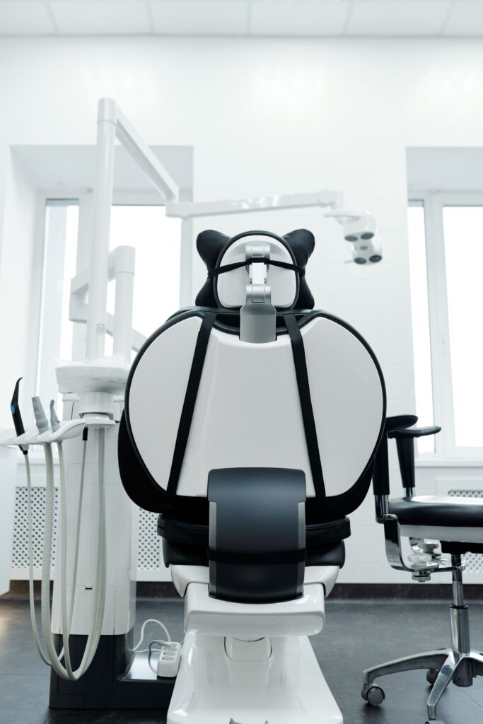 Stock photograph of an empty dental clinic room with a modern dental chair and equipment. Not a client practice.