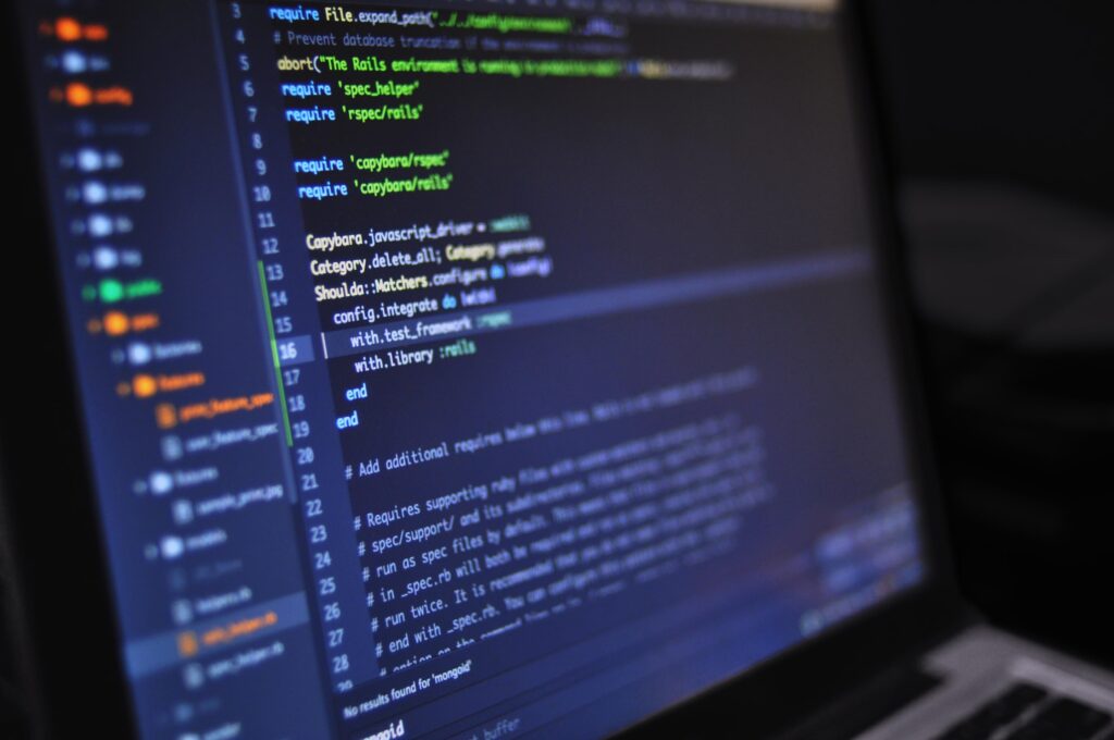 Stock photograph of programming code on a computer screen in a dark room