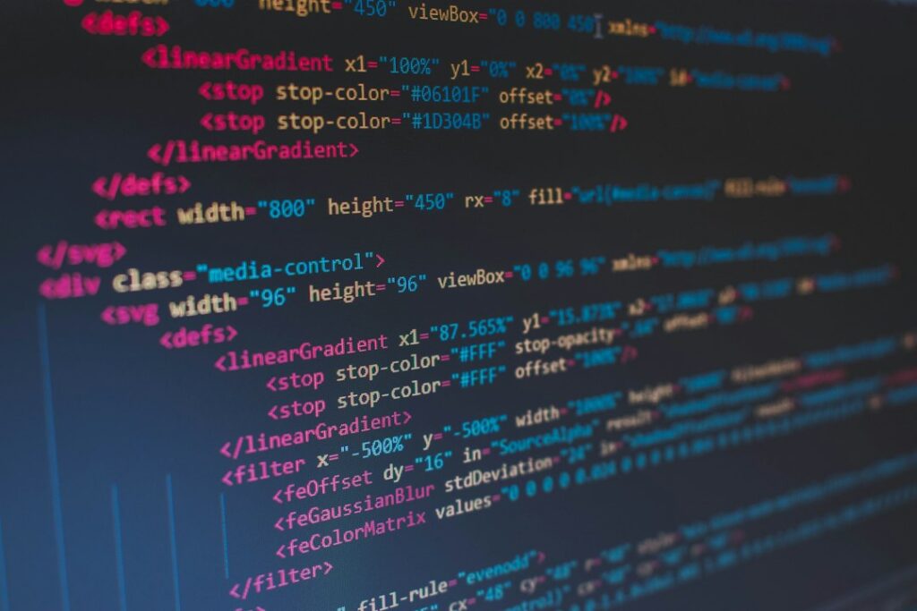 Stock photograph of coloured source code on a dark screen. It is a licensed stock image and not a screenshot of any site discussed in this article.